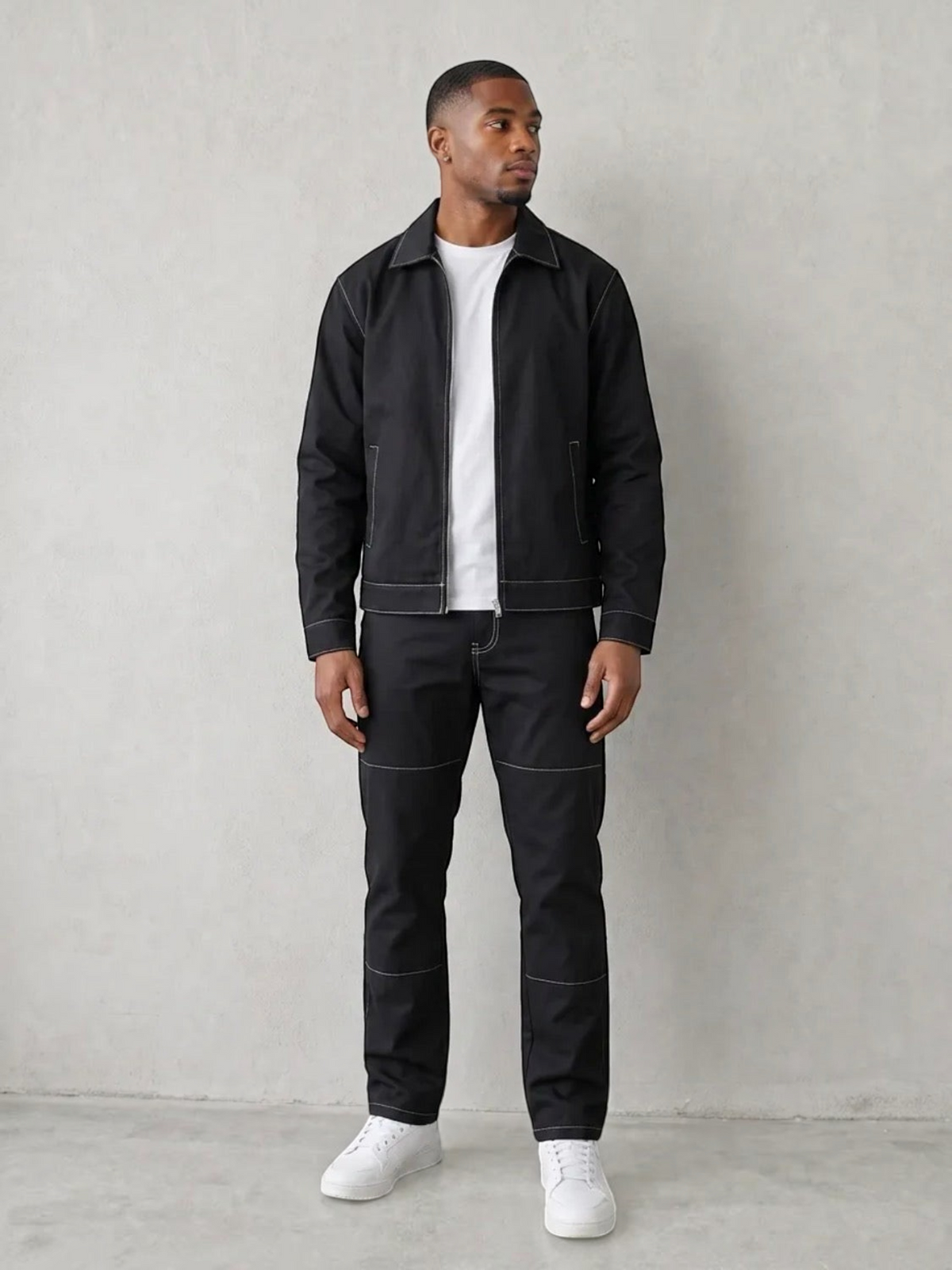 BROCK men's black two-piece jacket and trousers set with white contrast stitching worn by a model with white sneakers