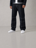 BROCK blue denim pants with white contrast stitching and matching jacket, worn with white sneakers.