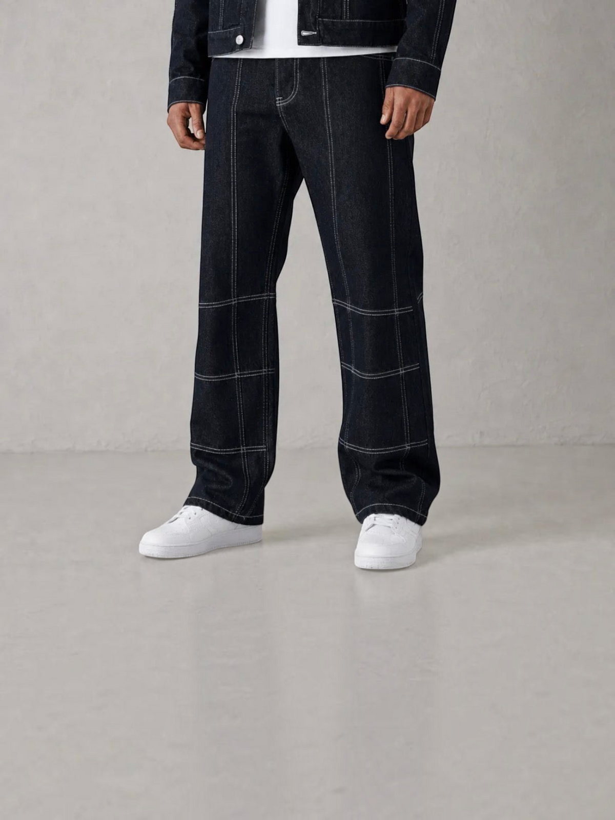BROCK blue denim pants with white contrast stitching and matching jacket, worn with white sneakers.