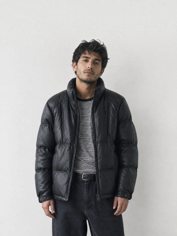 BROCK black faux leather puffer jacket worn by a man over a striped shirt against a plain light background