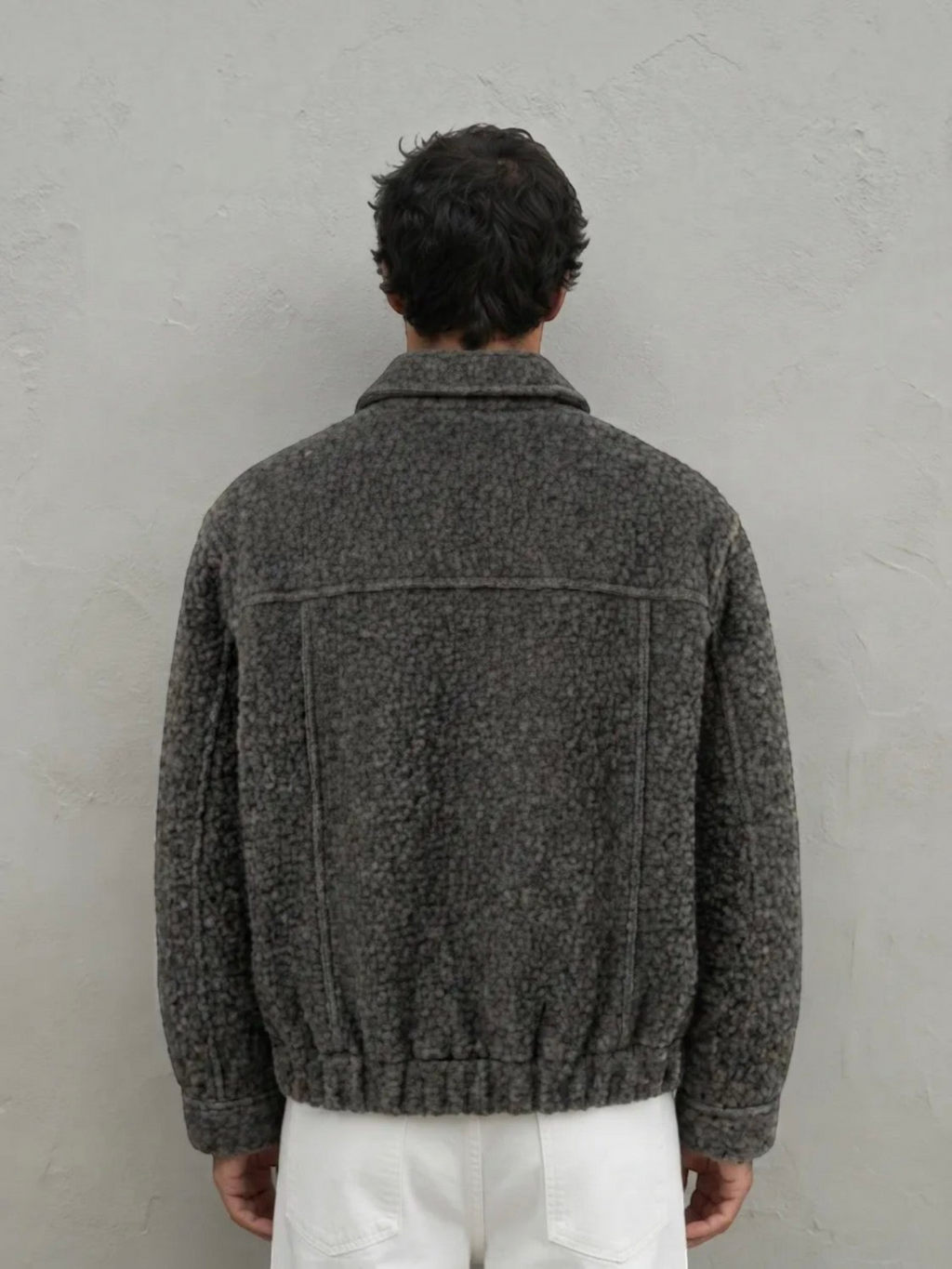 Back view of a man wearing a BROCK textured grey short jacket with a structured fit and ribbed hem