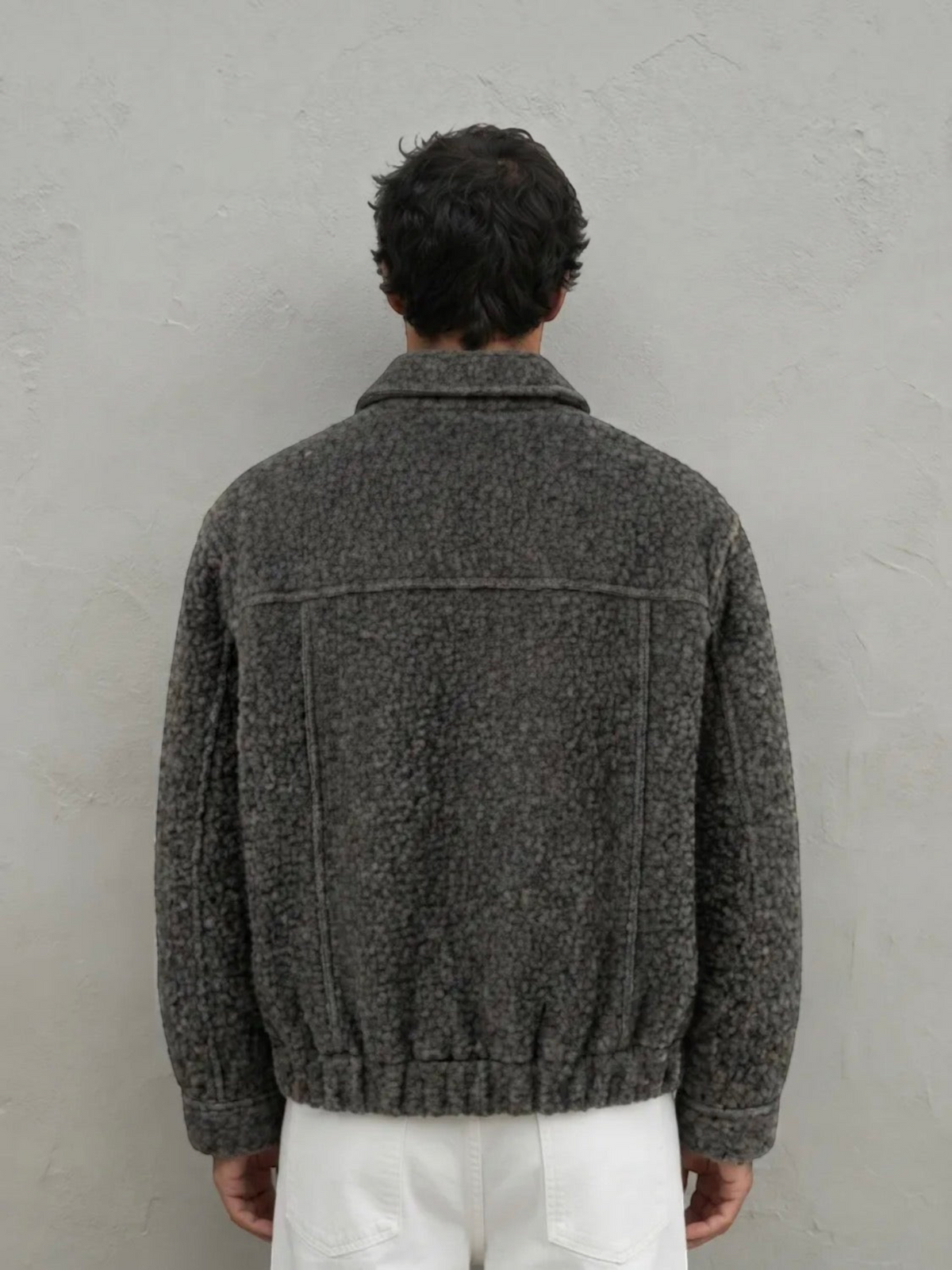 Back view of a man wearing a BROCK textured grey short jacket with a structured fit and ribbed hem