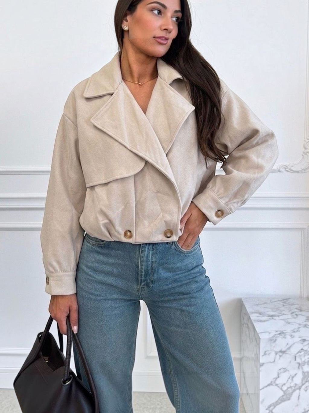 BROCK ESTEE BROWN beige faux suede cropped jacket with wide lapels and button cuffs worn with blue jeans
