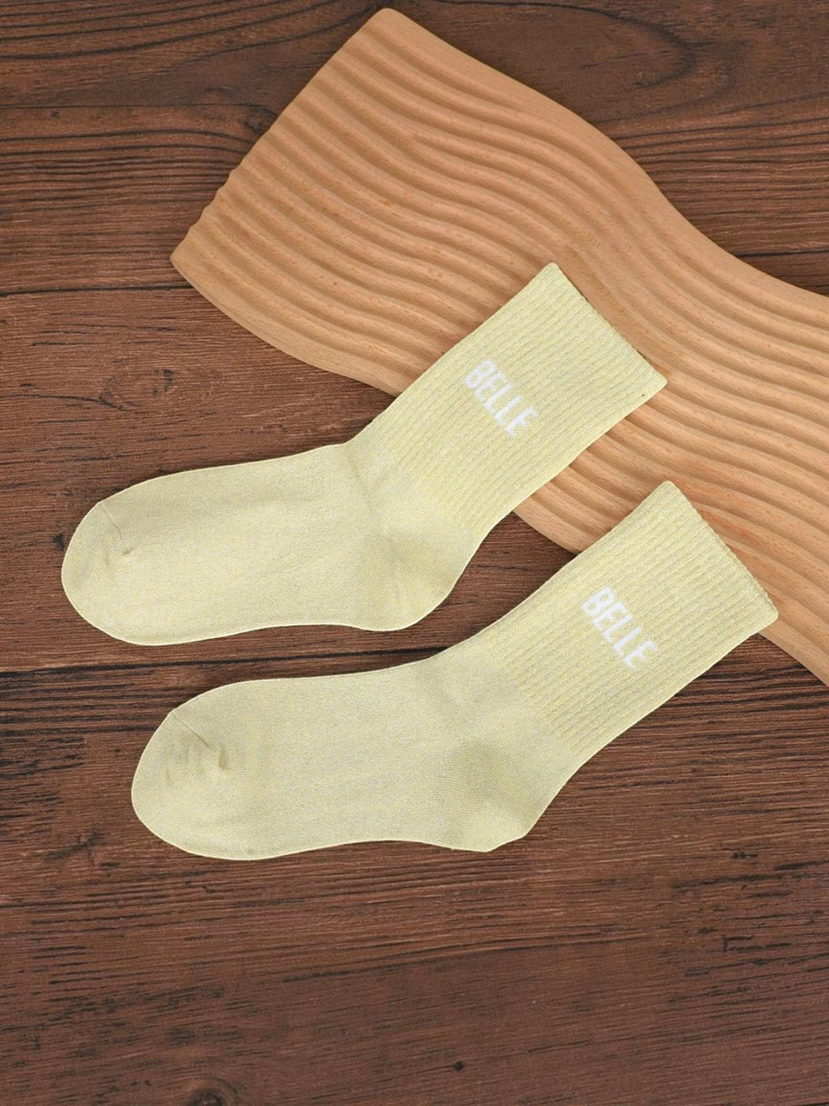 Chaussettes BROCK mi-mollet jaune pâle pailletées avec inscription brodée BELLE sur fond bois