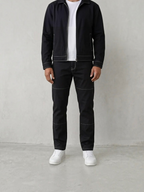 BROCK men's black two-piece suit with white contrast stitching, featuring a structured jacket and matching trousers.