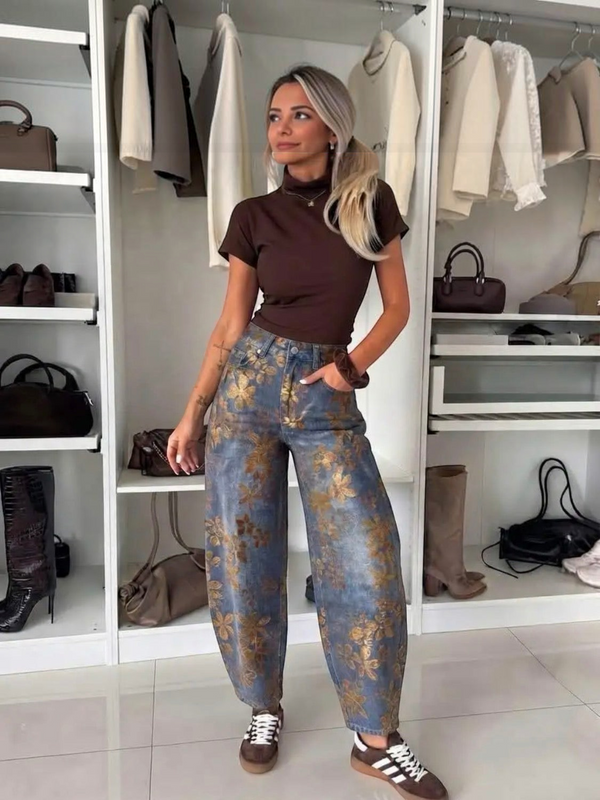 BROCK ESTEE BROWN balloon jeans in blue denim with brown velvet floral patterns worn by a woman in a closet