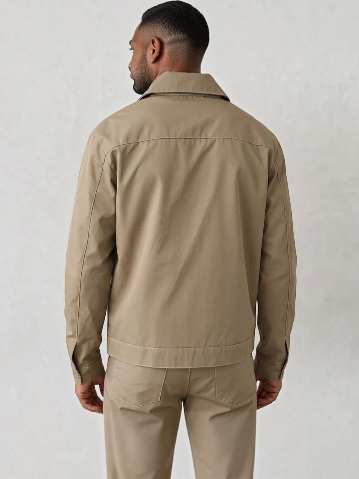 Back view of a man wearing a beige BROCK two-piece jacket and trousers set made of polyester and elastane blend.