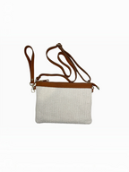 BROCK LOUISA LEE raffia pouch with tan cowhide leather trim and detachable shoulder strap on a white background