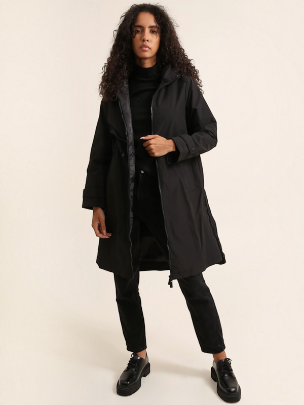 Model wearing a black BROCK long waterproof hooded jacket with a lightweight lining and adjustable fit.