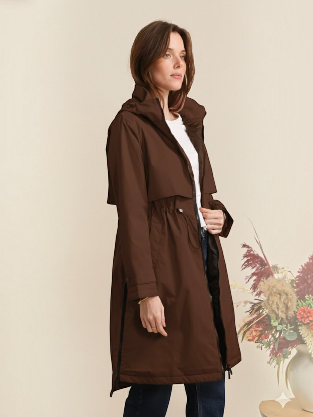 Model wearing a brown BROCK long waterproof hooded jacket with an adjustable waist and lightweight lining