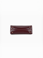 Base du sac à main BROCK GALLANTRY bordeaux avec quatre pieds de protection métalliques dorés