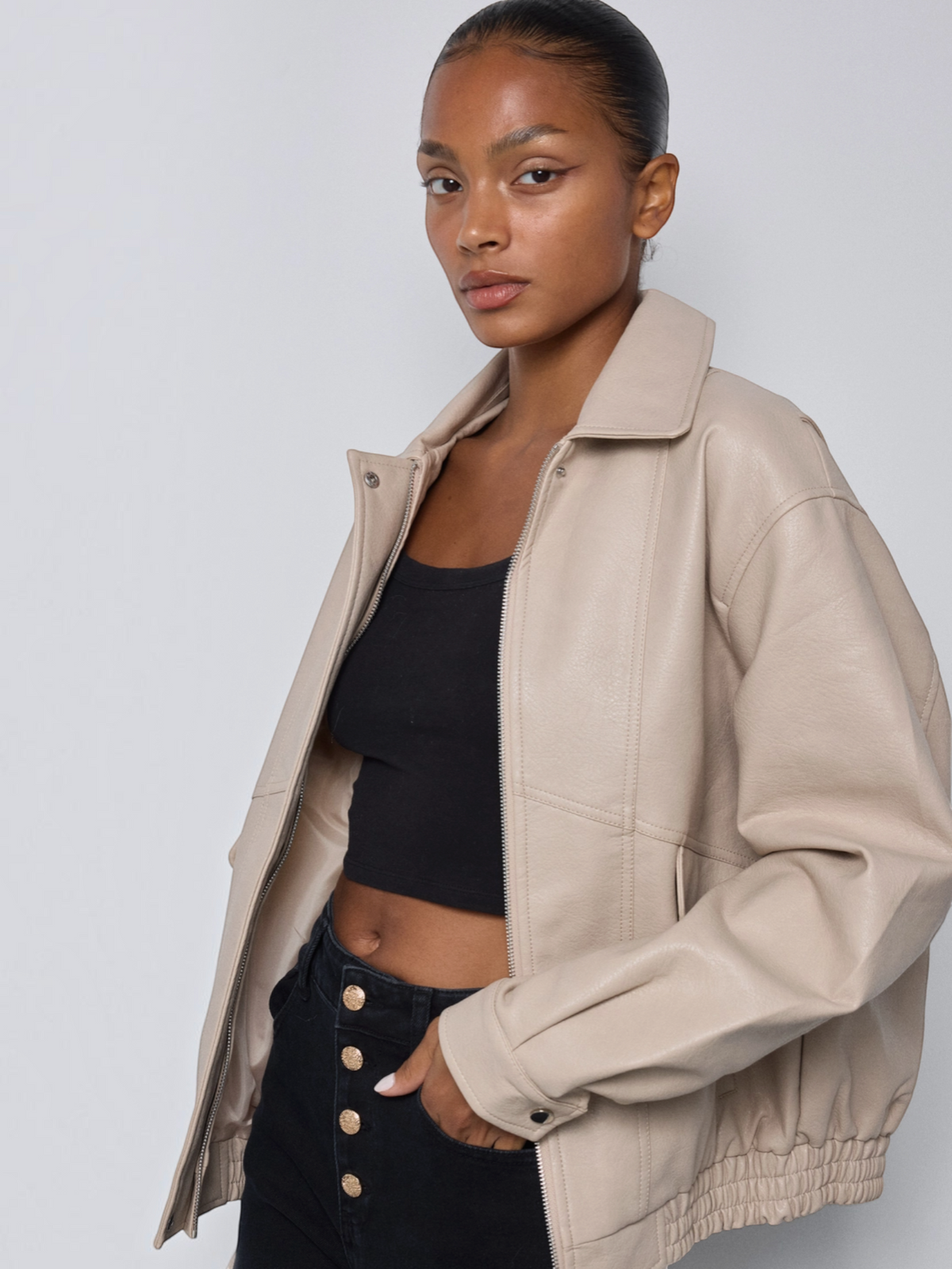 Veste bomber en similicuir beige BROCK avec col rabattu, coupe ample et finitions élastiquées portée par une femme