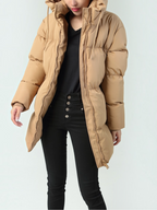 Doudoune mi-longue matelassée beige BROCK COPPEROSE avec capuche, portée par une femme sur fond clair