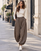 Femme portant un pantalon ample à carreaux BROCK avec taille élastiquée et bas resserrés, style décontracté urbain.