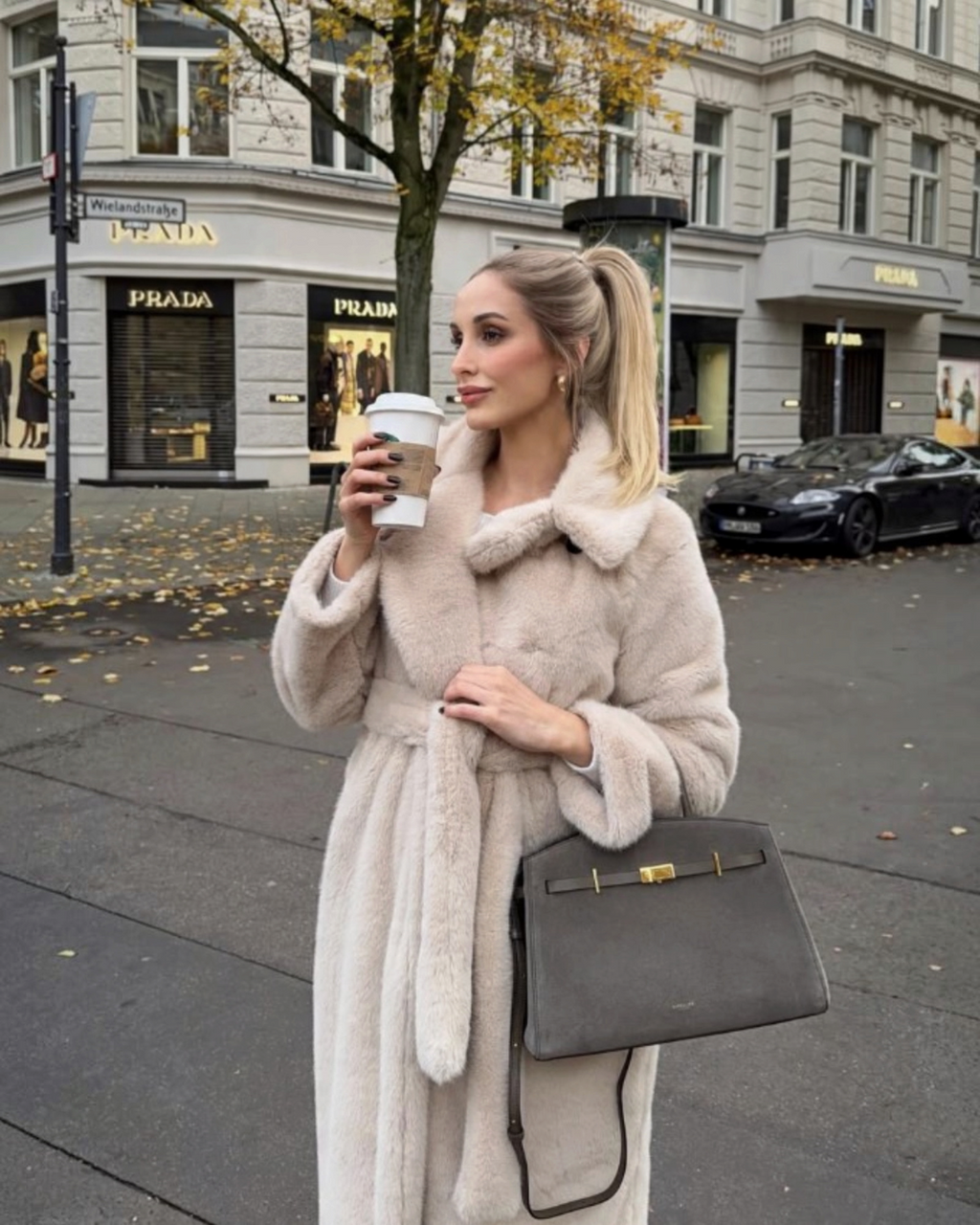 Femme portant un manteau long en fausse fourrure beige BROCK avec ceinture à nouer et grand col à revers en ville