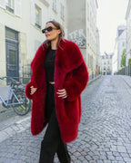 Manteau mi-long BROCK en fausse fourrure rouge effet renard avec grand col à revers porté par une femme en ville