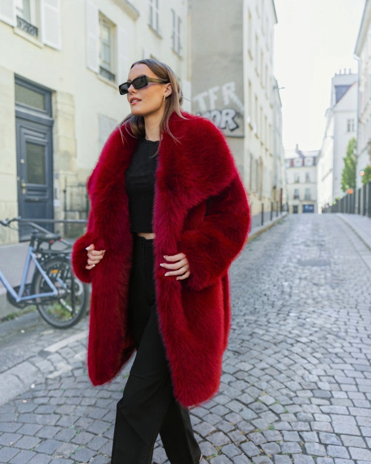 Manteau mi-long BROCK en fausse fourrure rouge effet renard avec grand col à revers porté par une femme en ville