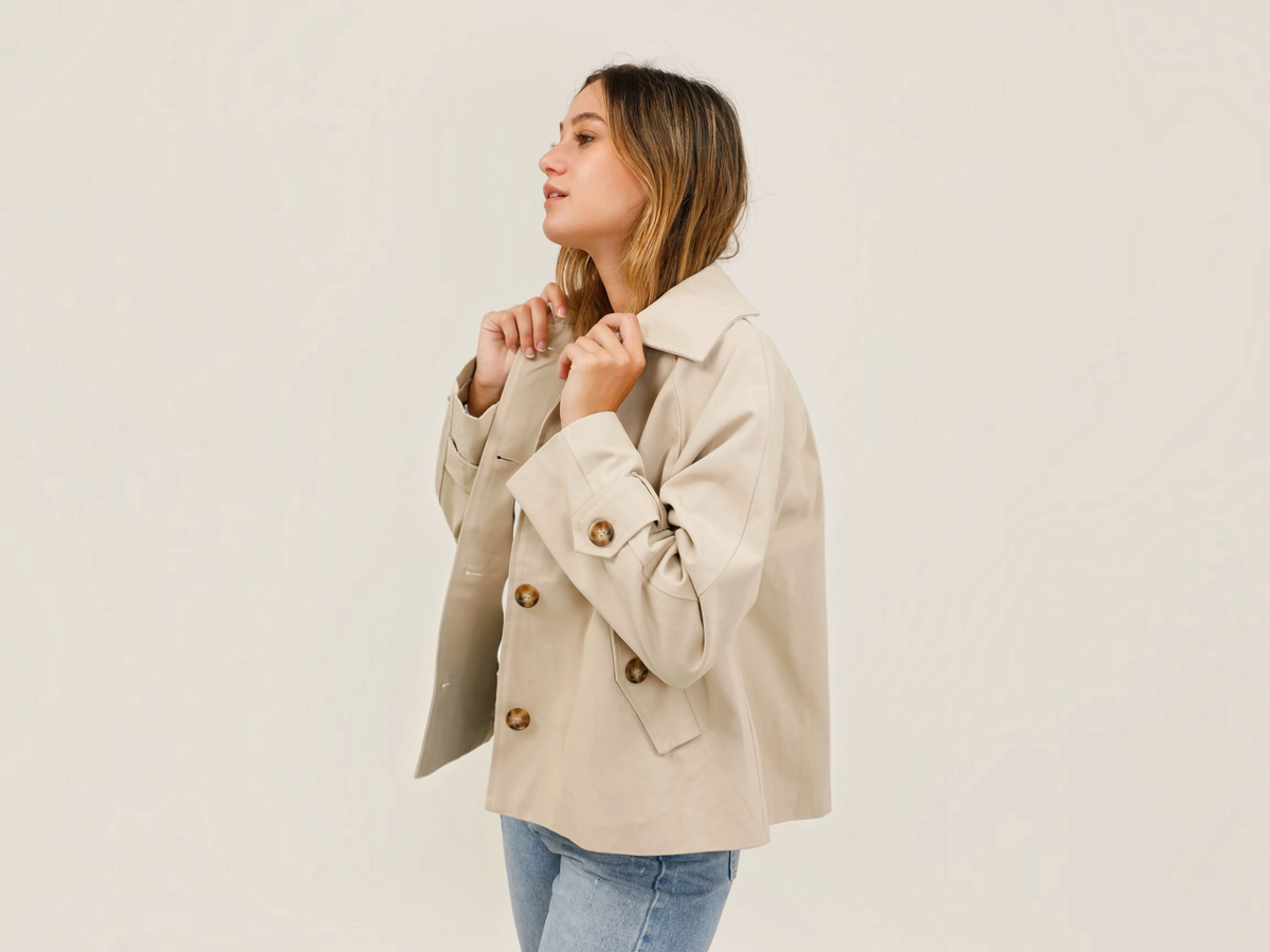 Veste courte beige ATTRAIT PARIS par BROCK avec col chemise, poches à rabat et boutons, portée par une femme