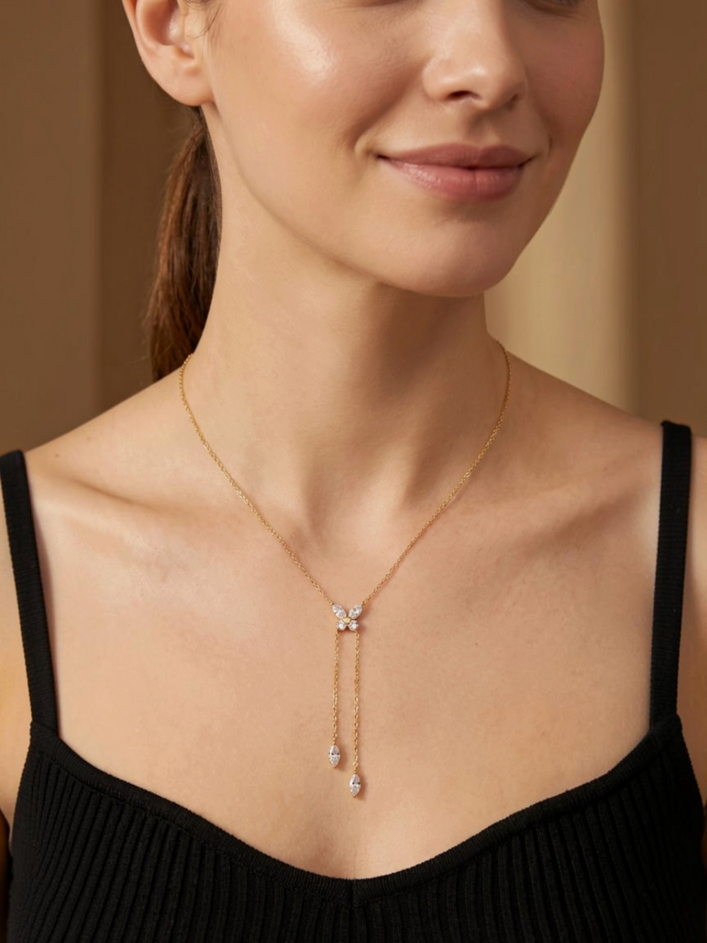 Collier BROCK en acier inoxydable doré avec pendentif papillon brillant et chaînes pendantes sur une femme