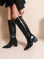 BROCK JOIA black patent leather knee-high boots with a pointed toe and block heel worn by a model