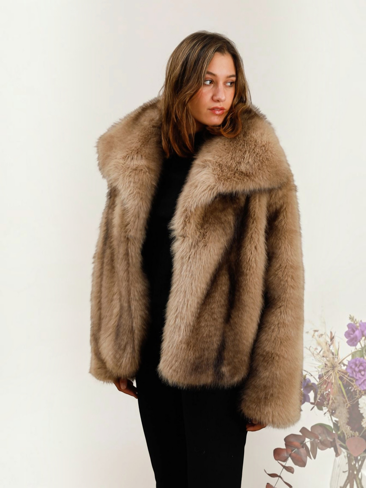 Manteau oversize BROCK DIX-ONZE en fausse fourrure beige avec un large col structuré porté par une femme