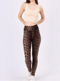 Modèle portant un legging BROCK à motif léopard taille haute avec un haut court beige sur fond blanc