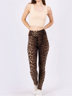 Modèle portant un legging BROCK à motif léopard taille haute avec un haut court beige sur fond blanc