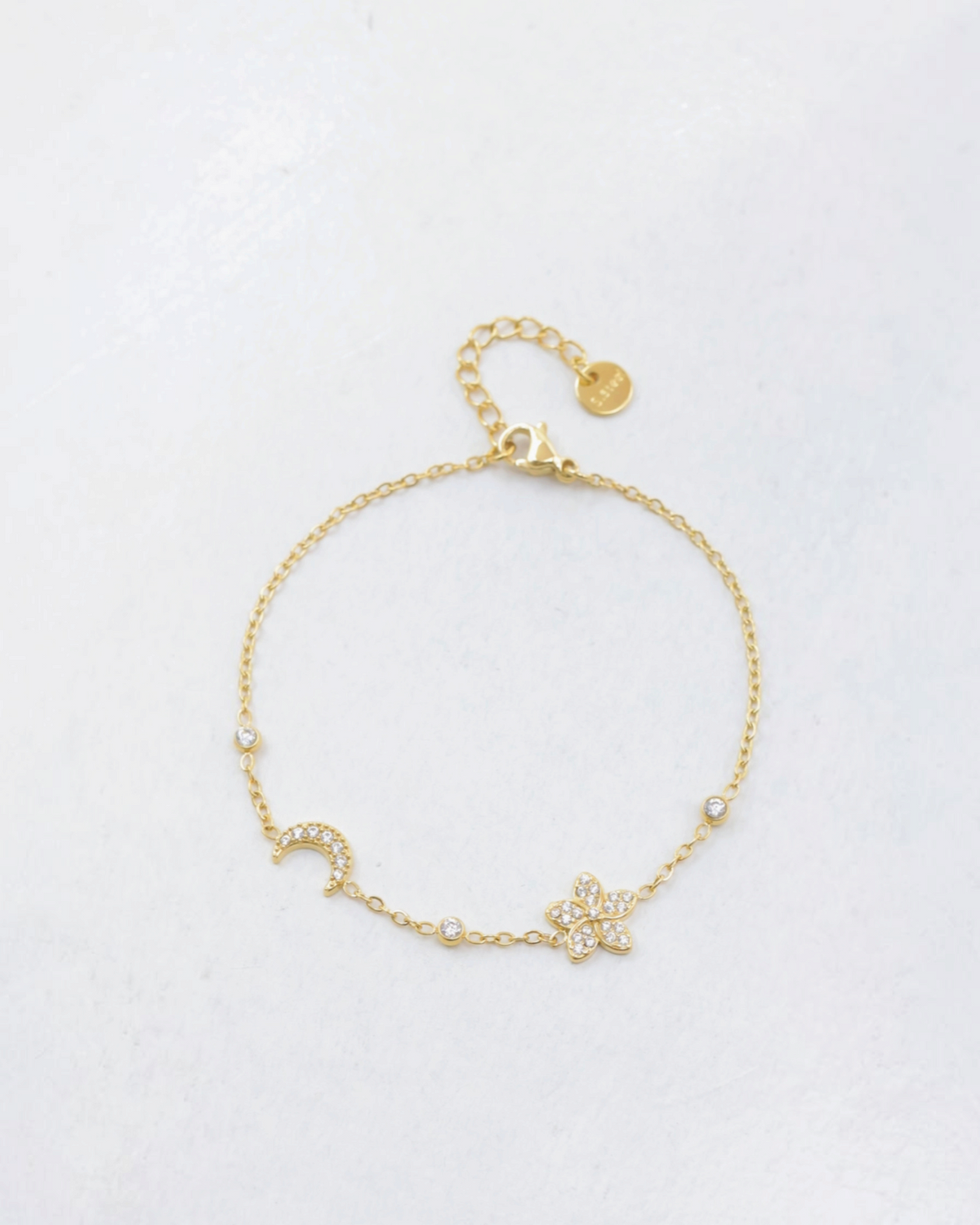 Bracelet BROCK en acier inoxydable doré avec motifs lune et trèfle sertis de cristaux brillants sur chaîne fine