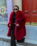 Femme portant un manteau mi-long BROCK en fausse fourrure rouge effet renard avec un grand col à revers