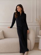 Femme portant un ensemble BROCK en maille côtelée noire composé d'un gilet zippé et d'un pantalon droit confortable