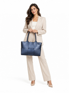 Femme en tailleur beige tenant un sac cabas bleu en cuir Dollaro tressé de la marque BROCK