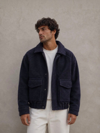 BROCK navy blue textured short jacket with a structured collar and front pockets worn by a man