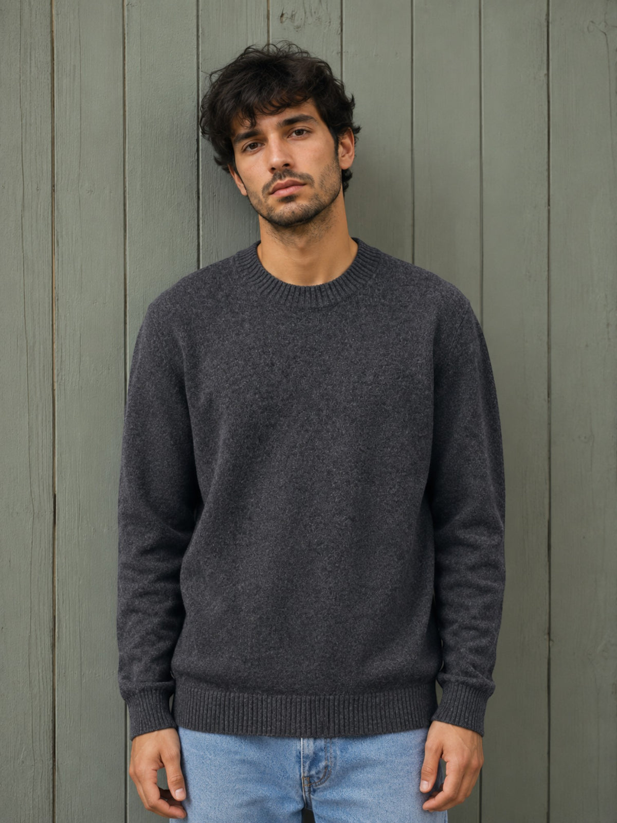 BROCK KZ DIFFUSION grey wool blend crew neck sweater worn by a man against a rustic wooden wall