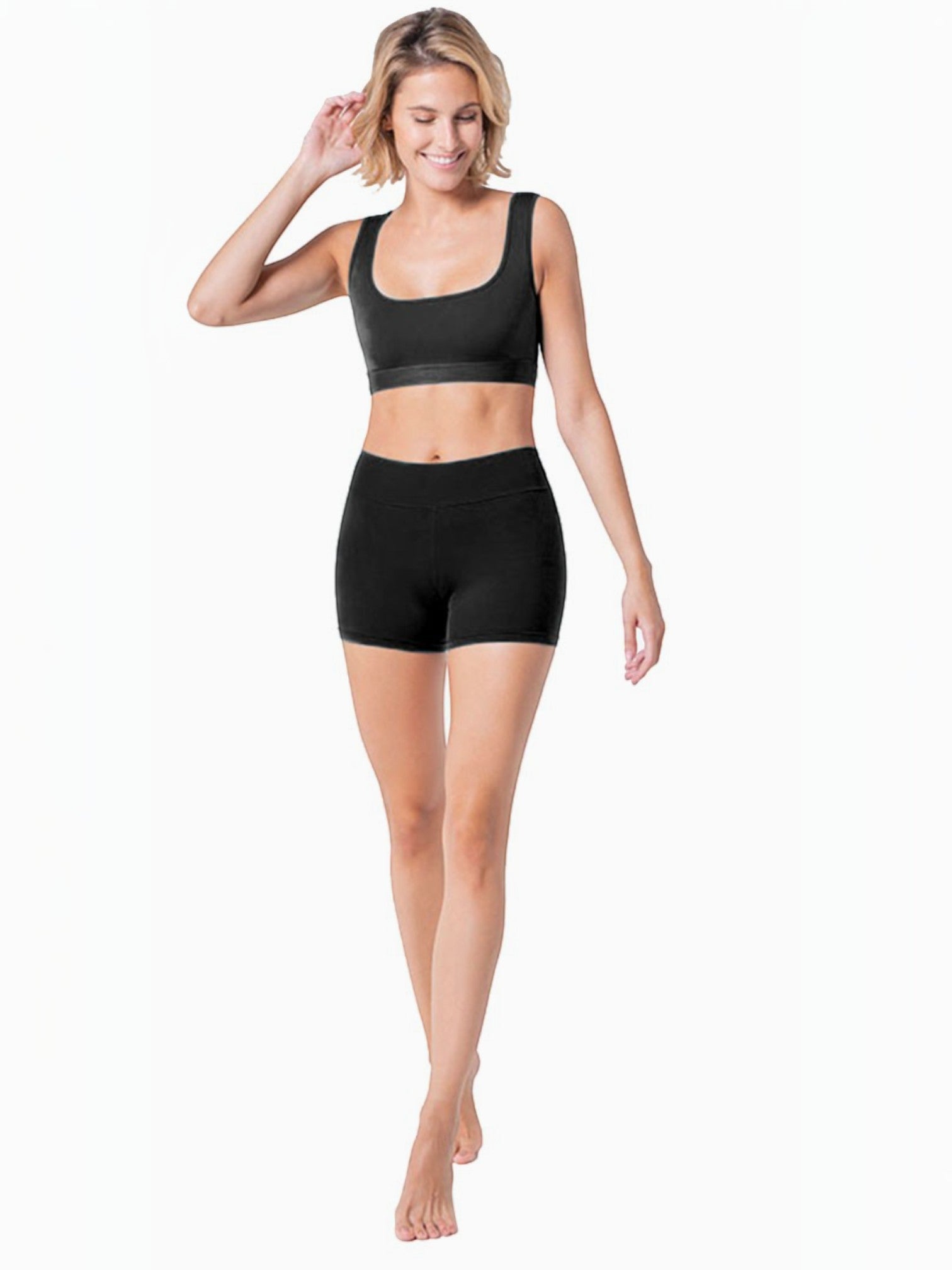 Woman wearing BROCK ANAISSA black high-density sports shorts and matching crop top for yoga and fitness training.