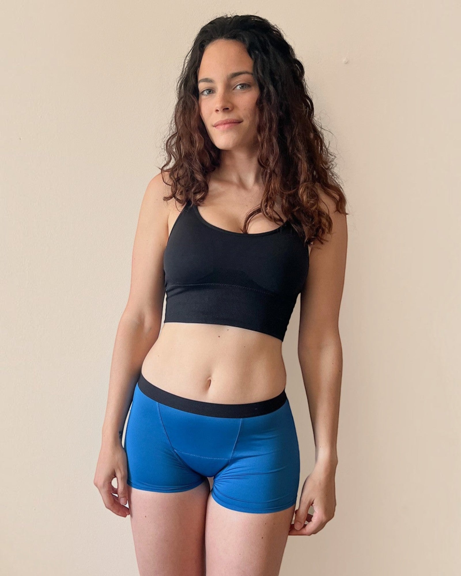 BROCK ANAISSA teen menstrual shorts in blue, worn by a woman with curly hair, featuring a slim, leak-proof design.