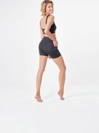 Woman wearing black BROCK ANAISSA Halasana sports shorts with side pocket, made from firming 3D Ymax fabric.
