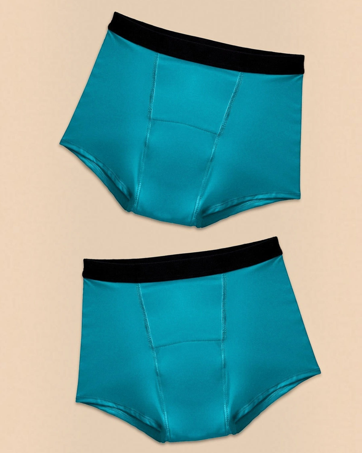 Two BROCK ANAISSA Marie teen menstrual shorts in teal with black waistbands, made from organic cotton and bamboo.