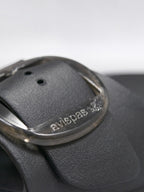 Close-up of a black BROCK AVISPAS Milano EVA sandal featuring a translucent adjustable oval buckle