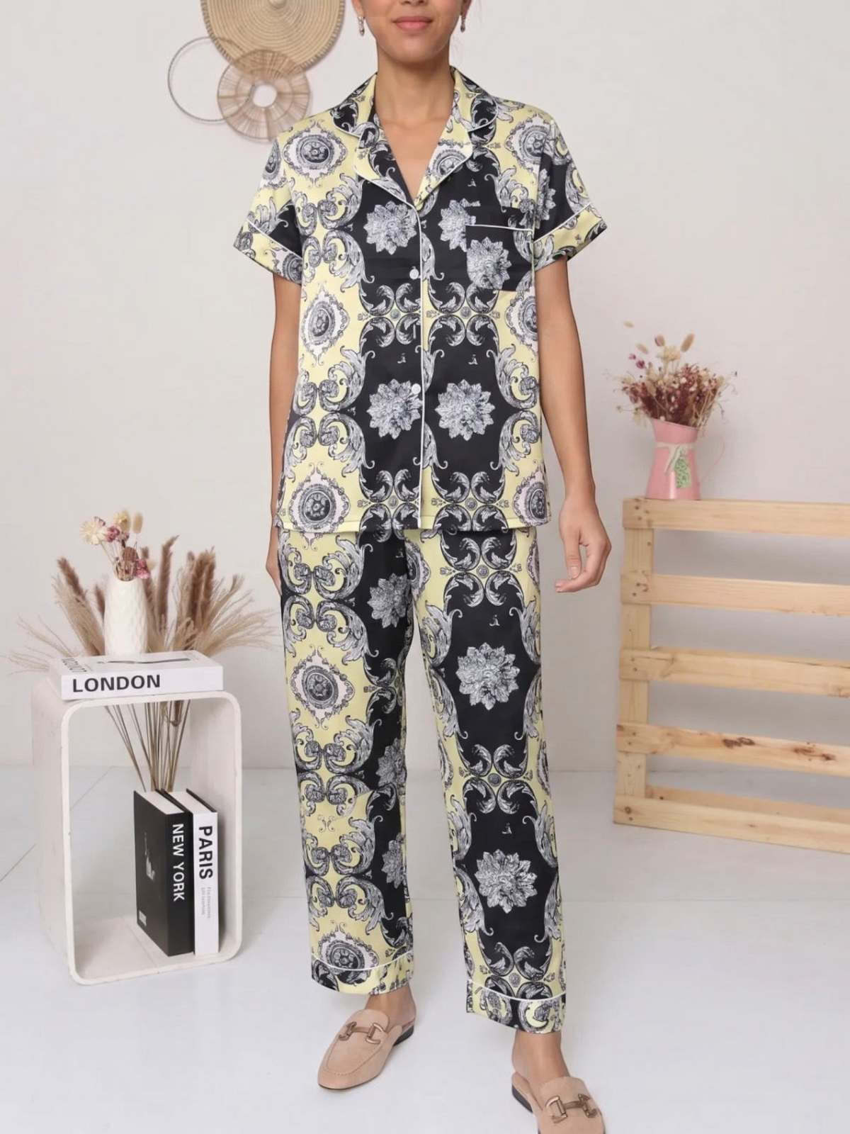Model wearing a BROCK BELLE COM'ELLE satin pajama set with a black and yellow baroque print and short sleeves.