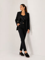 Model wearing BROCK black faux suede loafers with gold metallic detail and low block heel in a studio setting