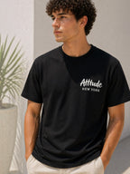 BROCK men's black cotton t-shirt with white Attitude New York chest print, worn by a model in a casual setting.