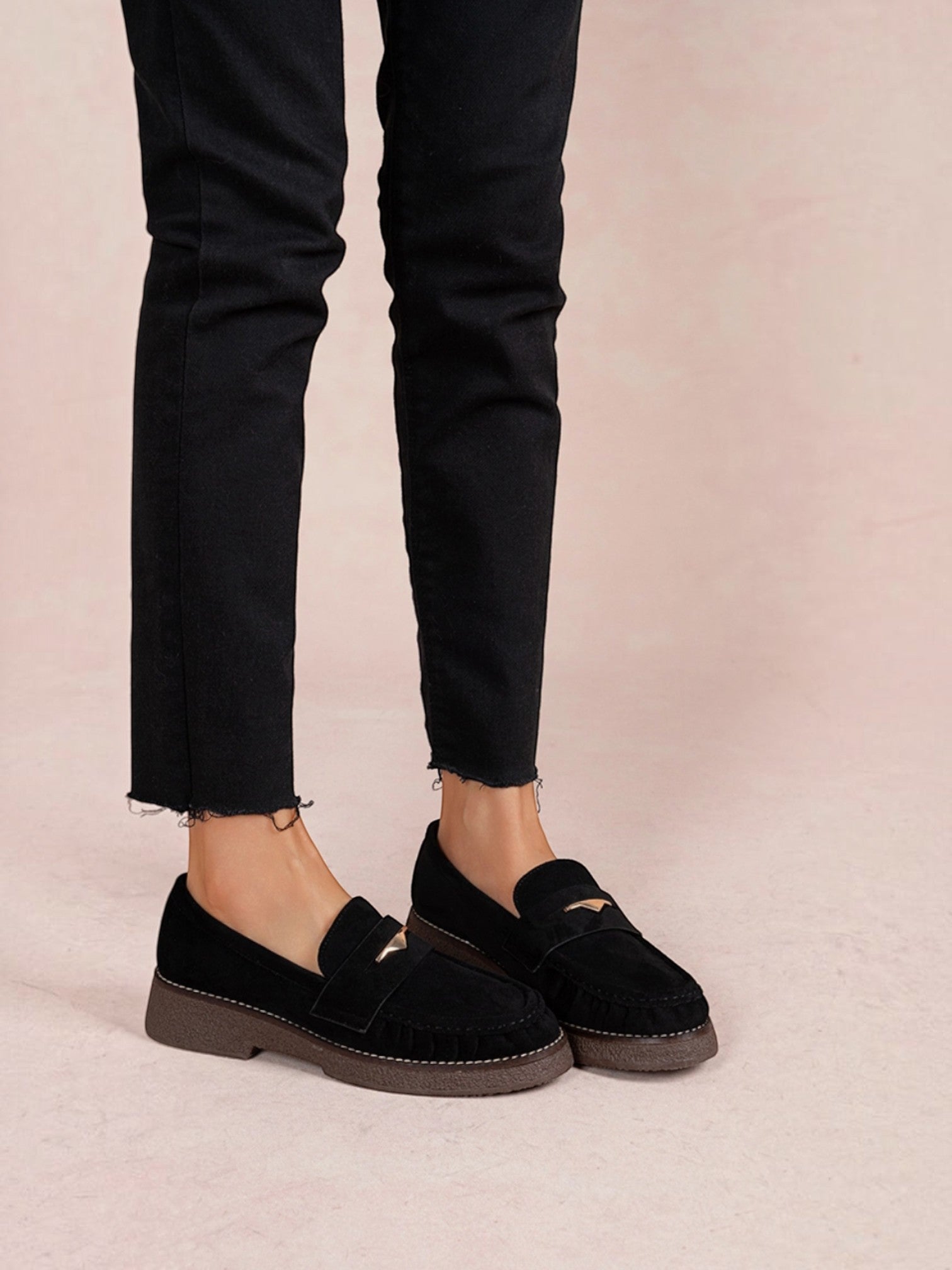 BROCK black faux suede loafers with gathered detail, gold metallic accent, and low block heel worn with black jeans