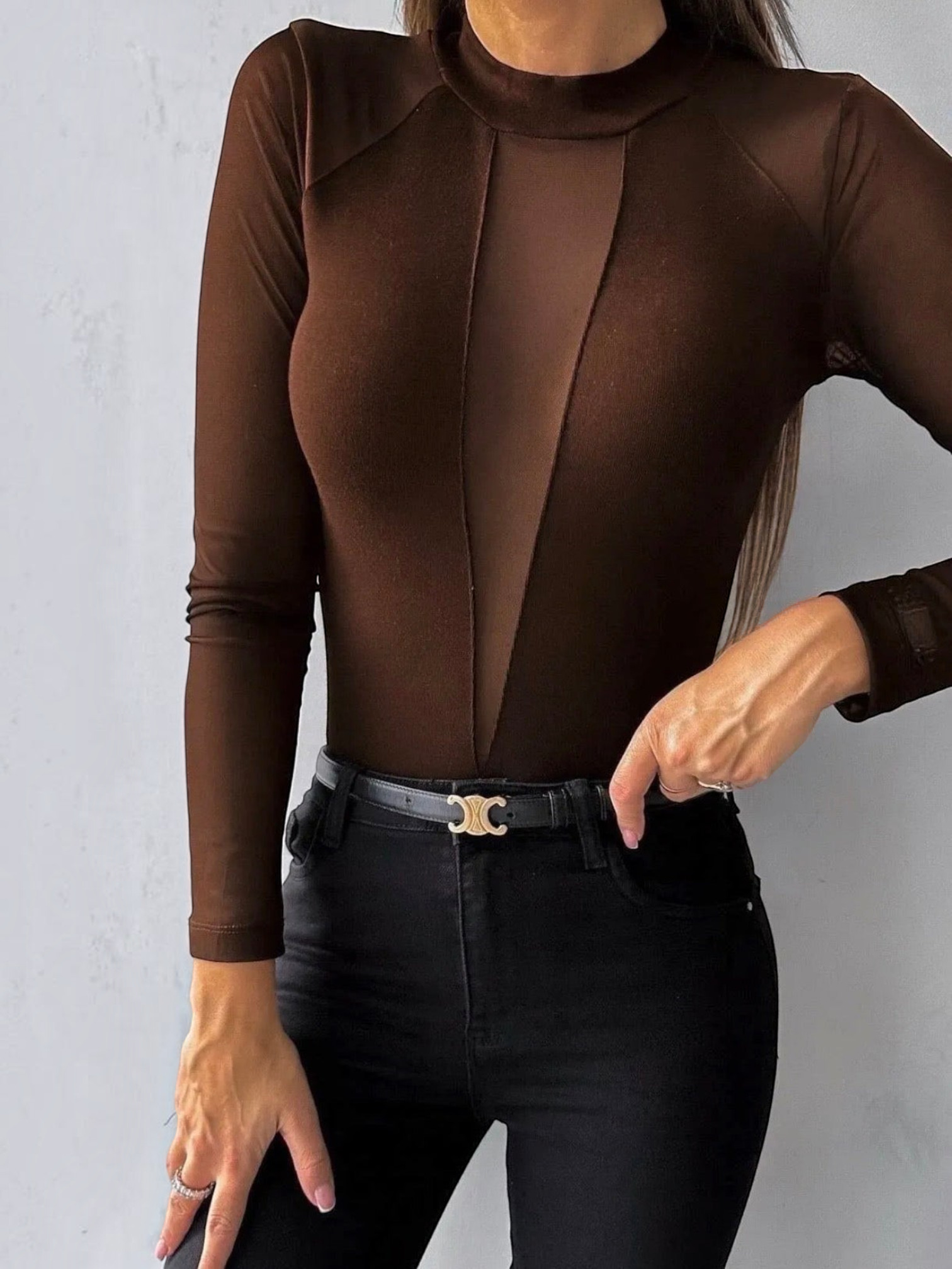 BROCK brown long-sleeve bodysuit with a mock neck and sheer mesh panels on the chest and sleeves.