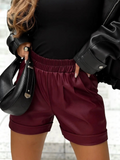 BROCK burgundy faux leather shorts with an elasticated waist and cuffed hems worn with a black top and jacket