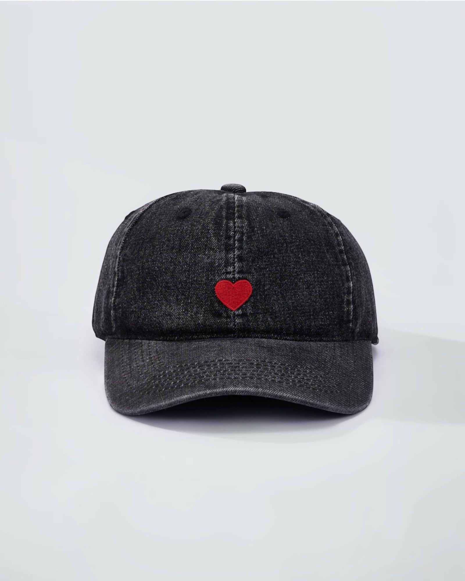 Casquette BROCK en coton noir délavé avec broderie cœur rouge sur le devant. Style décontracté.