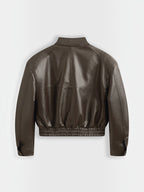Back view of a chocolate brown Copperose faux leather cropped jacket with a stand collar and elasticated hem by BROCK