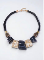 BROCK collier fantaisie en résine et corde noire avec pendentifs rectangulaires et ovales, détails dorés.