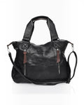 BROCK COLMA large black faux leather tote bag with decorative zipper tassels, dual handles, and adjustable strap.