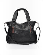 BROCK COLMA large black faux leather tote bag with decorative zipper tassels, dual handles, and adjustable strap.