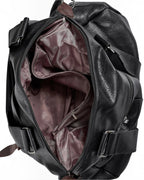 BROCK COLMA large black faux leather tote bag with open main compartment, interior pockets, and zipper details.